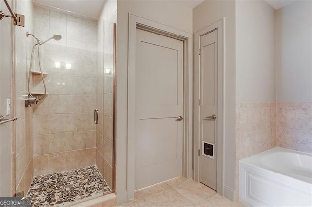 bathroom featuring tile patterned flooring and separate shower and tub