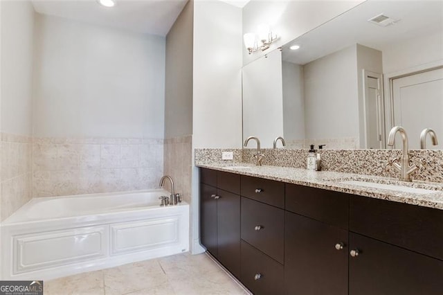 bathroom with a tub to relax in, tile patterned floors, and vanity