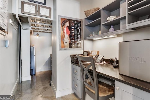 interior space featuring built in desk and concrete floors