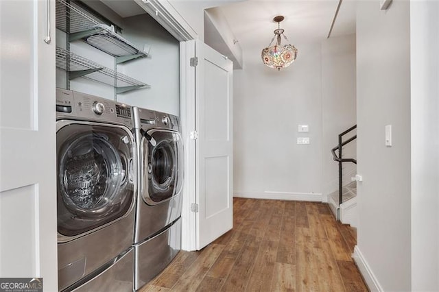 clothes washing area with hardwood / wood-style floors and independent washer and dryer