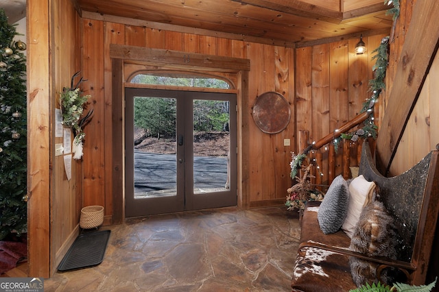 doorway to outside with french doors, wooden walls, and wood ceiling