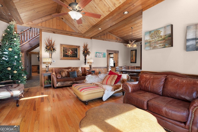 living room with lofted ceiling with beams, ceiling fan with notable chandelier, hardwood / wood-style flooring, and wooden ceiling