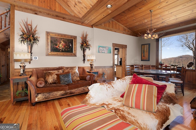 living room featuring wood ceiling, lofted ceiling with beams, a chandelier, and light hardwood / wood-style floors