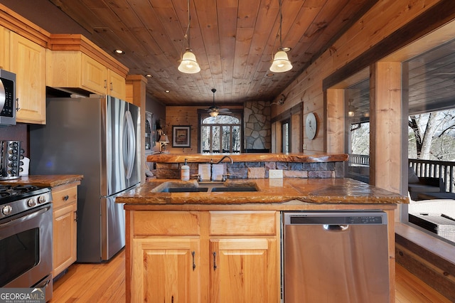 kitchen with pendant lighting, stainless steel appliances, plenty of natural light, and sink