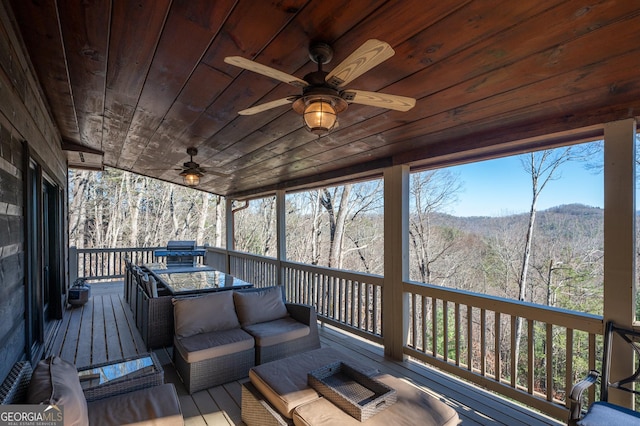 wooden deck with an outdoor living space and ceiling fan