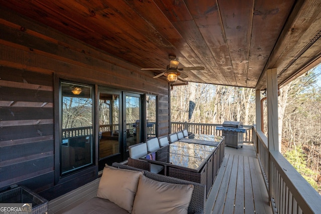 wooden deck with area for grilling and ceiling fan