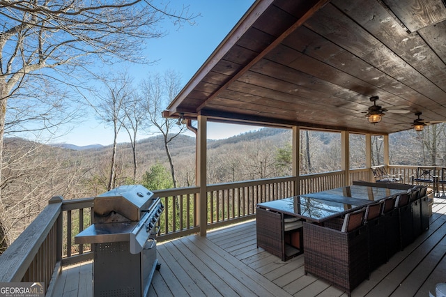 wooden terrace with a mountain view and ceiling fan