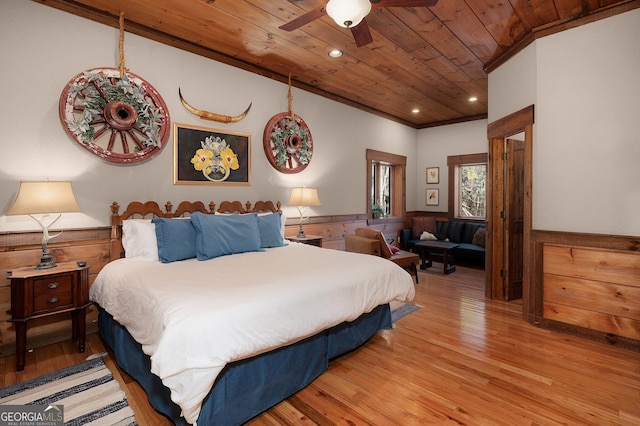 bedroom featuring ceiling fan, crown molding, light hardwood / wood-style floors, wooden walls, and wood ceiling