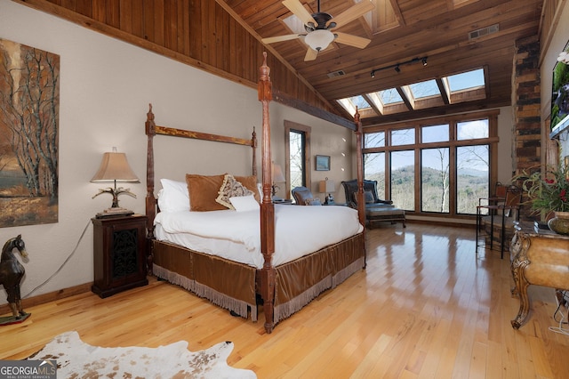 bedroom with a skylight, ceiling fan, wooden ceiling, high vaulted ceiling, and hardwood / wood-style floors