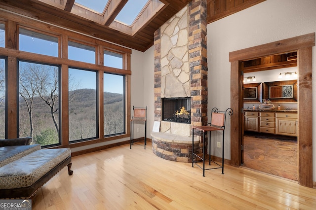 living room with a mountain view, a fireplace, high vaulted ceiling, and light hardwood / wood-style flooring