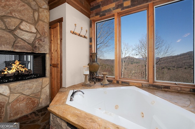 bathroom with a fireplace and a relaxing tiled tub