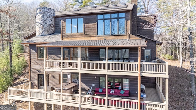 rear view of property featuring outdoor lounge area and a balcony