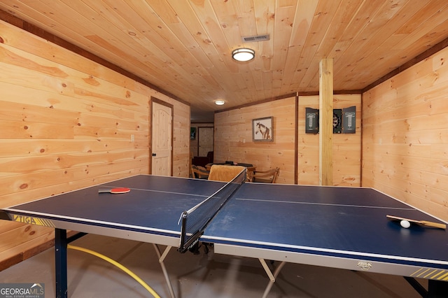 playroom with concrete flooring, wooden ceiling, and wood walls