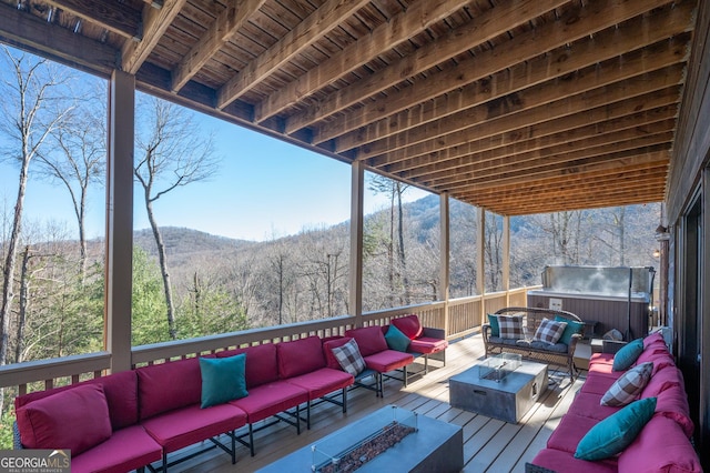 wooden terrace featuring an outdoor living space with a fire pit