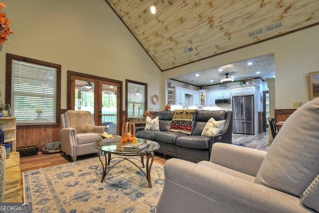 living room featuring french doors, high vaulted ceiling, light hardwood / wood-style floors, wooden walls, and wood ceiling