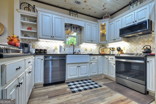 kitchen with decorative backsplash, stainless steel appliances, sink, white cabinets, and light hardwood / wood-style floors