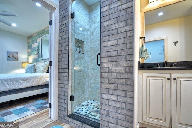 bathroom featuring hardwood / wood-style floors, vanity, and a shower with shower door