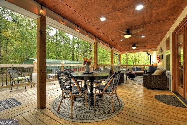 wooden deck with outdoor lounge area and ceiling fan