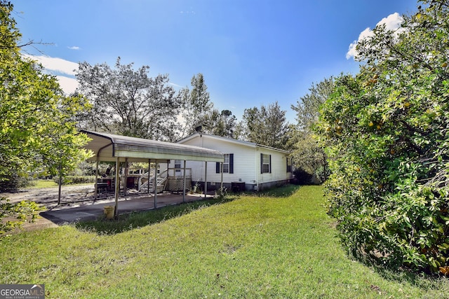 back of property featuring a lawn and a carport