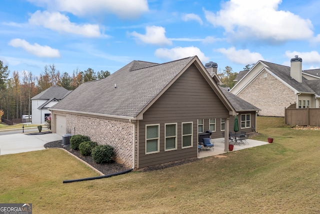 back of house featuring a garage, a yard, a patio, and central AC