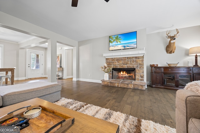 living room with a fireplace, ceiling fan, dark hardwood / wood-style flooring, and crown molding