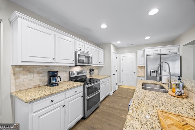 kitchen with white cabinets, decorative backsplash, stainless steel appliances, and dark hardwood / wood-style floors