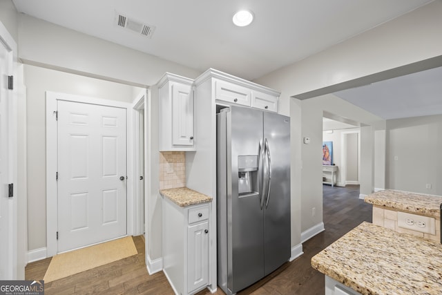 kitchen with white cabinets, stainless steel fridge, light stone counters, tasteful backsplash, and dark hardwood / wood-style flooring