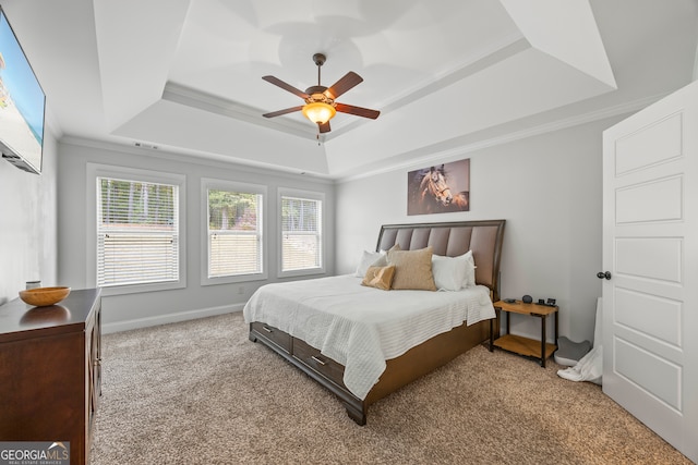 bedroom featuring multiple windows, a raised ceiling, ceiling fan, and ornamental molding