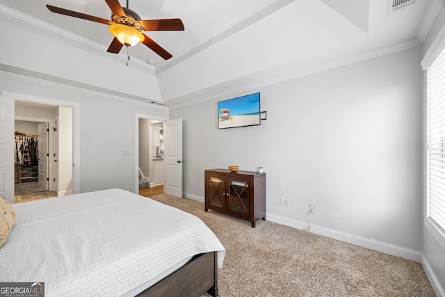 bedroom featuring a tray ceiling, crown molding, ceiling fan, and light colored carpet