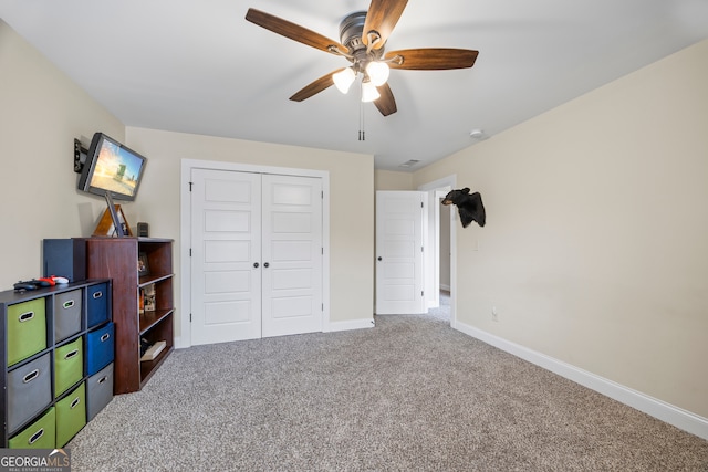 carpeted bedroom with ceiling fan and a closet