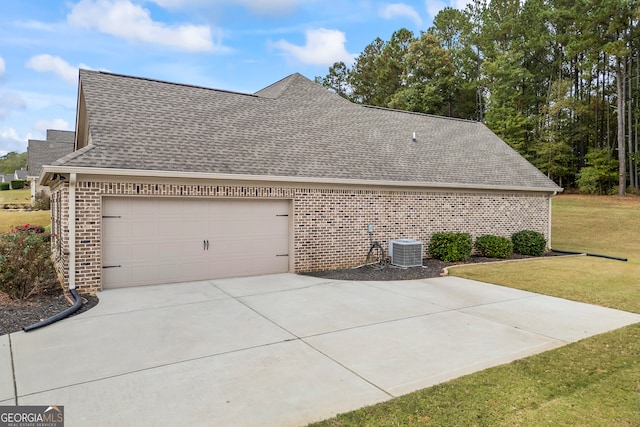 view of side of property featuring central air condition unit, a yard, and a garage