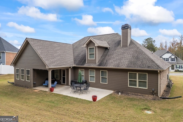 back of house featuring a patio area and a lawn