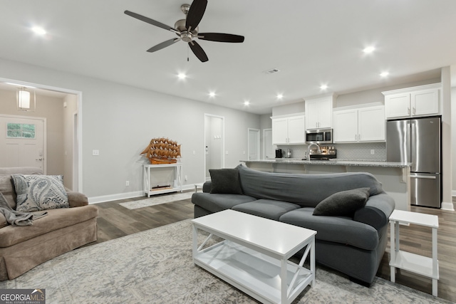 living room with hardwood / wood-style flooring, ceiling fan, and sink