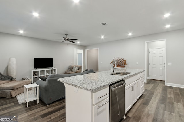 kitchen with light stone counters, stainless steel dishwasher, a kitchen island with sink, sink, and white cabinets