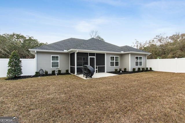 back of property with a sunroom, a yard, and a patio