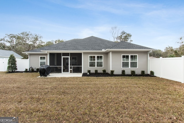 back of house featuring a lawn and a sunroom