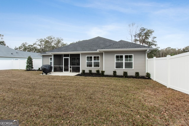 rear view of house featuring a yard, a patio area, and a sunroom