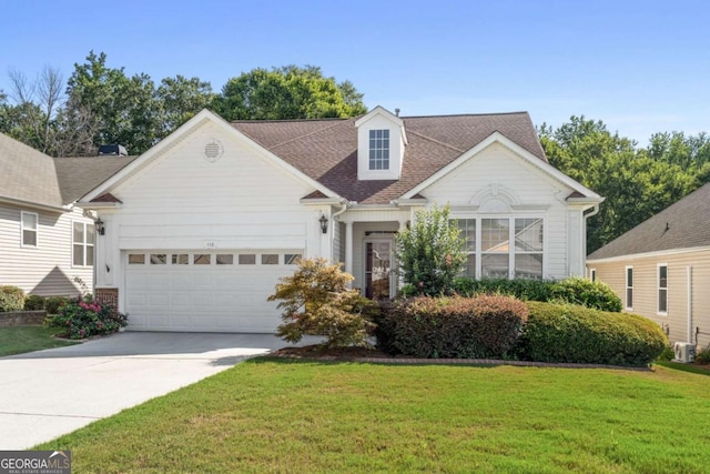 new england style home featuring driveway, an attached garage, a shingled roof, and a front lawn