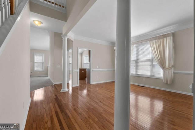entryway with ornate columns, ornamental molding, baseboards, and hardwood / wood-style flooring