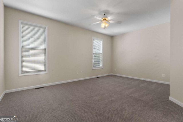 spare room with baseboards, carpet floors, ceiling fan, and visible vents