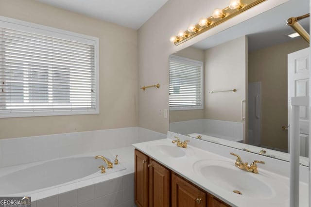 full bath featuring plenty of natural light, a sink, and a garden tub