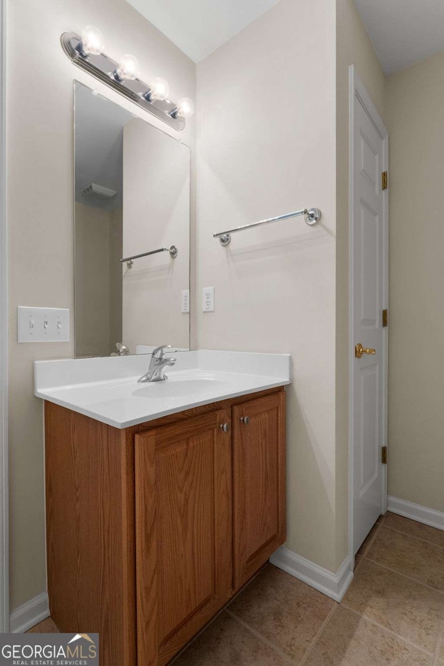 bathroom featuring tile patterned floors, baseboards, and vanity