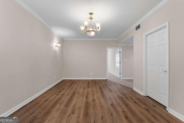 empty room featuring crown molding, baseboards, a chandelier, and visible vents