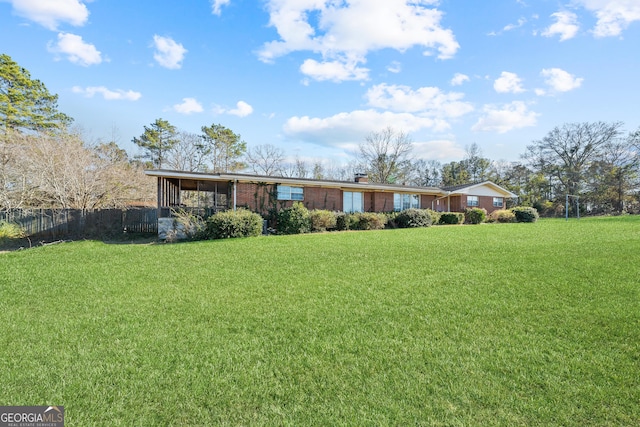 single story home featuring a sunroom and a front yard