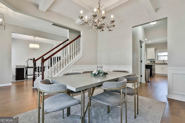 dining room with beamed ceiling, sink, dark wood-type flooring, and an inviting chandelier