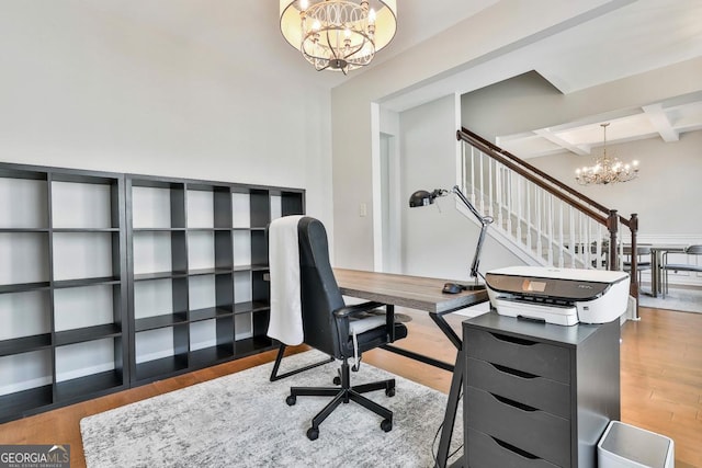 home office with hardwood / wood-style floors, beamed ceiling, coffered ceiling, and a notable chandelier