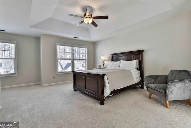 bedroom with a tray ceiling, ceiling fan, and light colored carpet