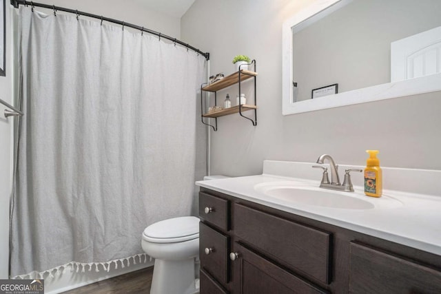 bathroom featuring vanity, wood-type flooring, and toilet