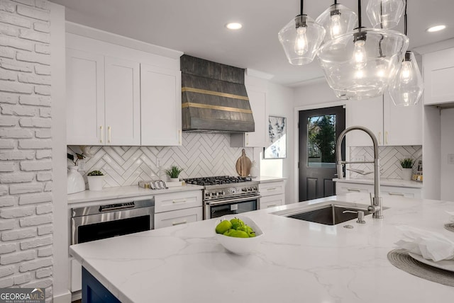 kitchen featuring high end stainless steel range, light stone counters, white cabinetry, and pendant lighting