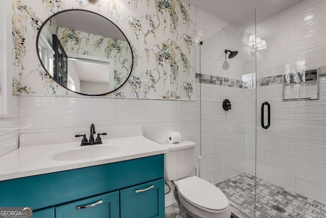 bathroom with toilet, vanity, tile walls, and walk in shower